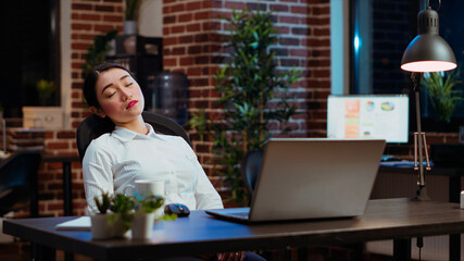 Tired employee asleep on computer desk chair suddenly waking up, struggling to finish writing...