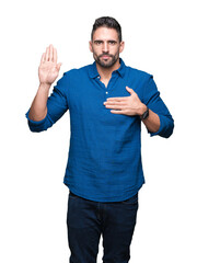 Young handsome man over isolated background Swearing with hand on chest and open palm, making a...