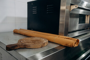 Commercial kitchen setup with oven, cutting board in industrial setting with rustic touch