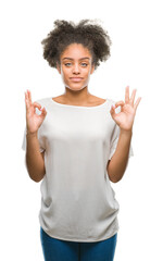 Young afro american woman over isolated background relax and smiling with eyes closed doing meditation gesture with fingers. Yoga concept.