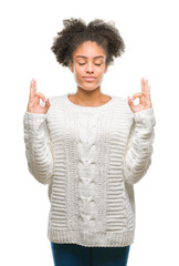 Young afro american woman wearing winter sweater over isolated background relax and smiling with eyes closed doing meditation gesture with fingers. Yoga concept.