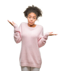 Young afro american woman wearing winter sweater over isolated background clueless and confused...
