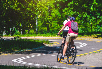 Naklejka premium Cyclists ride on the bike path in the city Park 