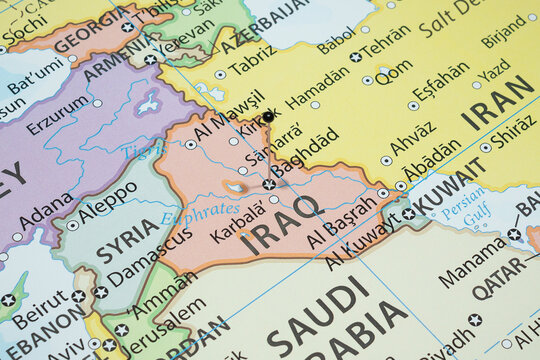 Close up to a Baghdad city with a black pin needle into Iraq country political map 