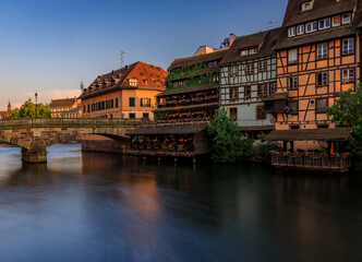 Half timbered houses by canals of Petite France in Strasbourg, France at sunset