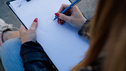 Hands Of A Woman Drawing On A Notebook