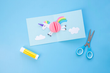 Colorful three-dimensional paper craft project, highlighted by scissors and glue, illustrating the hands-on creation process and emphasizing creativity and skill