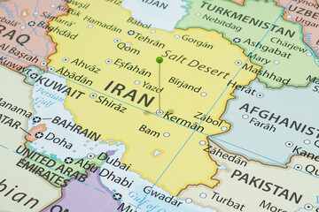 Close up to a Kerman city with a green pin needle into Iran country political map 