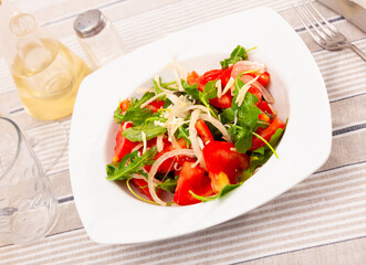 Healthy tasty salad of tomatoes, arugula and fresh onions