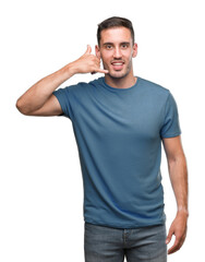 Fototapeta premium Handsome young casual man smiling doing phone gesture with hand and fingers like talking on the telephone. Communicating concepts.