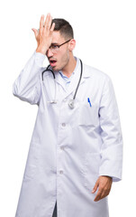 Fototapeta premium Handsome young doctor man surprised with hand on head for mistake, remember error. Forgot, bad memory concept.