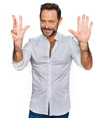 Fototapeta premium Middle age man wearing casual clothes showing and pointing up with fingers number nine while smiling confident and happy.
