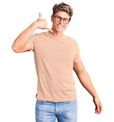 Young handsome man wearing casual clothes and glasses smiling doing phone gesture with hand and fingers like talking on the telephone. communicating concepts.