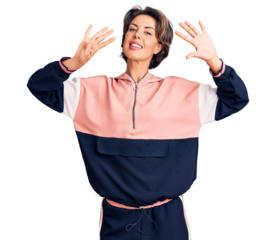 Young beautiful woman wearing sportswear showing and pointing up with fingers number nine while smiling confident and happy.