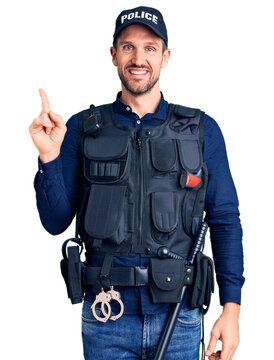 Young handsome man wearing police uniform with a big smile on face, pointing with hand finger to the side looking at the camera.