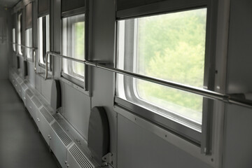 Windows and metal handrails in train car