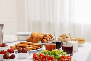 Different meals served on white table indoors. Buffet menu
