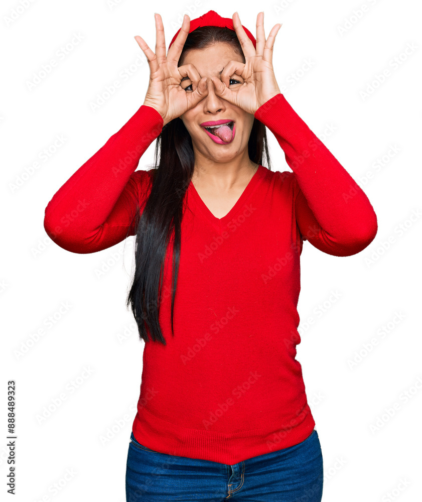 Canvas Prints young hispanic woman wearing casual clothes doing ok gesture like binoculars sticking tongue out, ey