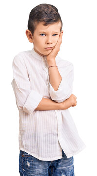 Cute blond kid wearing elegant shirt thinking looking tired and bored with depression problems with crossed arms.