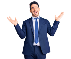 Young hispanic man wearing business clothes celebrating victory with happy smile and winner expression with raised hands