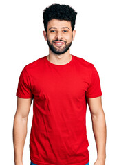 Fototapeta premium Young arab man with beard wearing casual red t shirt with a happy and cool smile on face. lucky person.