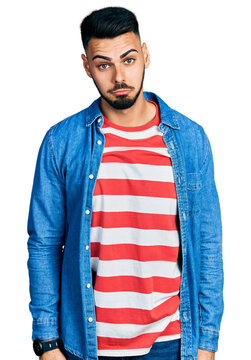 Young hispanic man with beard wearing casual denim jacket depressed and worry for distress, crying angry and afraid. sad expression.