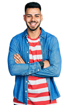 Young hispanic man with beard with arms crossed gesture smiling with a happy and cool smile on face. showing teeth.