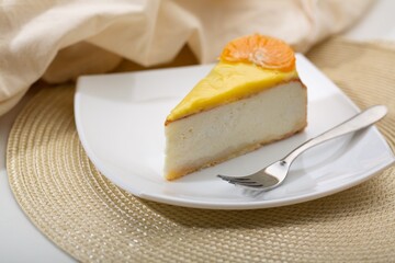 Delicious orange cheesecake with cream on plate