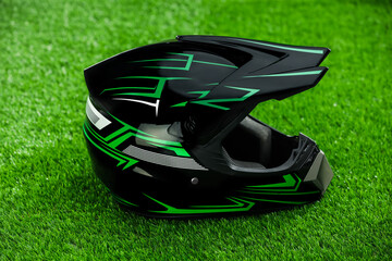 Modern motorcycle helmet with visor on green grass