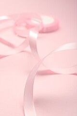 Beautiful ribbon reel on pink background, closeup