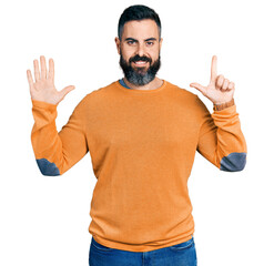 Hispanic man with beard wearing casual winter sweater showing and pointing up with fingers number seven while smiling confident and happy.