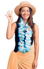 Young beautiful latin girl wearing hawaiian lei and summer hat showing and pointing up with fingers number four while smiling confident and happy.