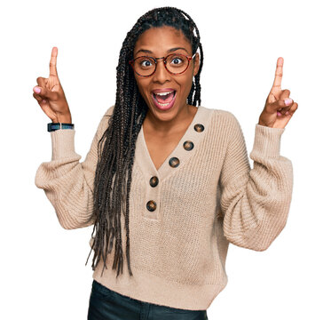 African american woman wearing casual clothes smiling amazed and surprised and pointing up with fingers and raised arms.