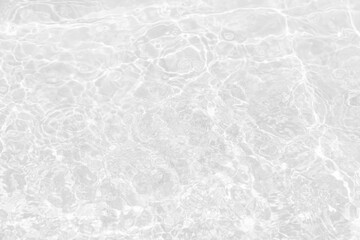 White water with ripples on the surface. Defocus blurred transparent white colored clear calm water surface texture with splashes and bubbles. Water waves with shining pattern texture background.