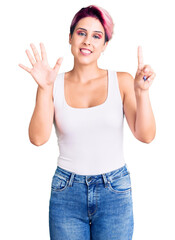 Young beautiful woman with pink hair wearing casual clothes showing and pointing up with fingers number six while smiling confident and happy.