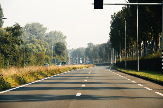 Empty highway in Haarlem, Netherlands on a warm summer day, viewed from the car window from a driver's perspective, showcasing a clear and tranquil road with scenic background plates