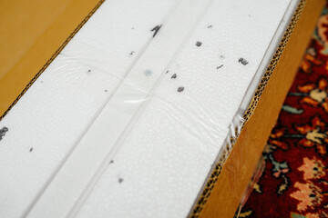 A cardboard box containing a styrofoam-protected item, showing the packaging details and protective materials used to ensure safe transportation.