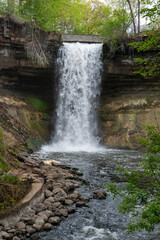 Minnehaha waterfall surrounded by trees and rock.