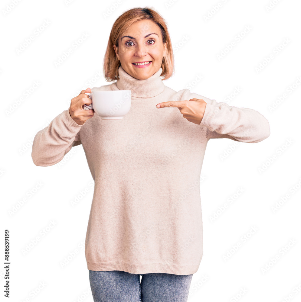 Wall mural Young blonde woman holding coffee smiling happy pointing with hand and finger