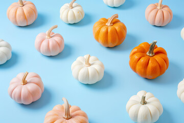 Four pumpkins of different colors are arranged on a blue background, generative ai image.