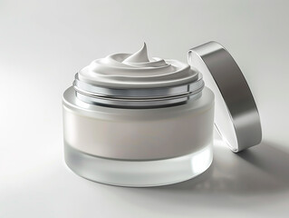 glass jar of beauty cream with silver lid resting on the side and reflected in the white plane