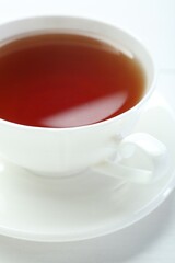 Aromatic tea in cup on white table, closeup