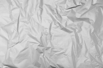 Crumpled silver foil as background, top view