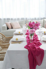 Beautiful table setting with pink peonies in dining room