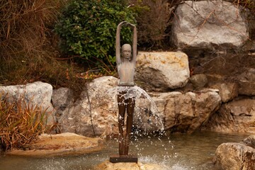 Statue man fountain in lake with stone.