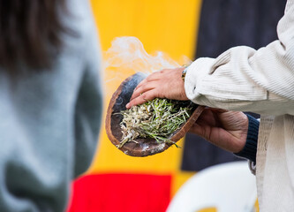 Australian Aboriginal Ceremony, man hand with green branches and flame, start a fire for a ritual...