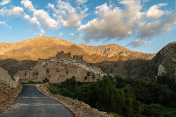 Fototapeta premium Al Bahah, Saudi Arabia: The road toward the Thee Ain, or Zee Ain ancient village in the mountains of Saudi Arabia in late afternoon with a cloudy blue sky