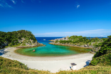 式根島の美しい青い海と白い砂浜の泊海水浴場と沖を行く漁船。

東京都伊豆諸島式根島-2020年10月3日
