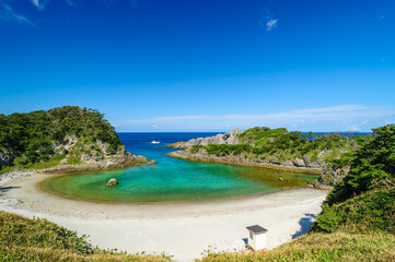 式根島の美しい青い海と白い砂浜の泊海水浴場と沖を行く漁船。

東京都伊豆諸島式根島-2020年10月3日
