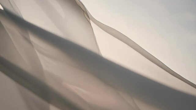 Cascading white fabric in soft focus. Gentle folds and creases create subtle shadows. Smooth curves and flowing lines evoke serenity. Muted beige tones add warmth to the ethereal composition.	